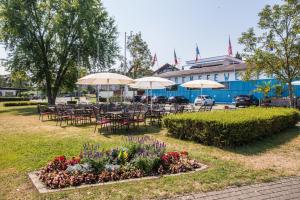 a group of tables and chairs with umbrellas and flowers at Hotel am Yachthafen in Konstanz