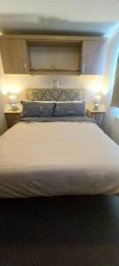 The Chill Out at Seton Sands في Port Seton: غرفة نوم بسرير كبير مع مواقف ليلتين