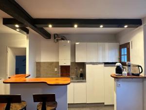 cocina con armarios blancos y encimera de madera en Appart COZY proche ORLY/PARIS, en Villeneuve-le-Roi