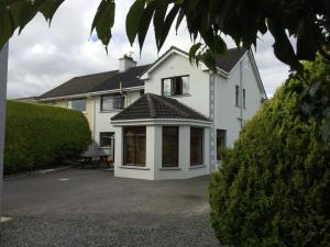 a white house with a large patio in front of it at Johnny B's B&B in Ballybofey