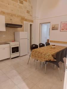 a kitchen with a table and chairs in a room at Casina Arianna in Leverano