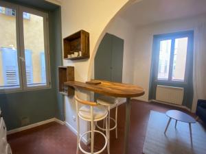 格拉斯的住宿－Appartement • centre historique Grasse，一个带桌子和两张凳子的小厨房