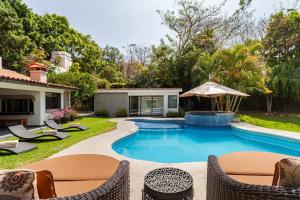 una piscina in un cortile con sedie e ombrellone di Casa vacacional alberca/jardín a Morelos