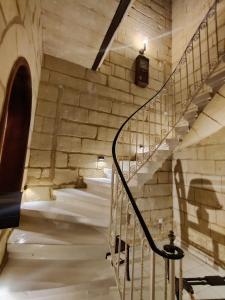 a spiral staircase in a building with a stone wall at Peaceful Traditional Maltese Townhouse in Luqa