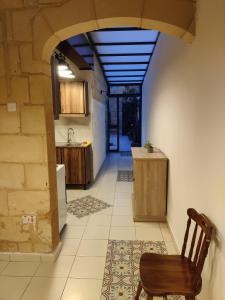 a kitchen with a table and a chair in a room at Peaceful Traditional Maltese Townhouse in Luqa