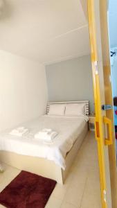 a bed with white sheets and pillows in a room at NK hostel P2 16/30 in Ban Song Hong