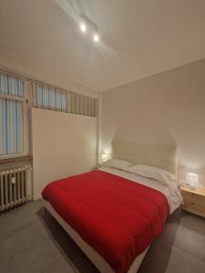 ein Schlafzimmer mit einem großen Bett mit einer roten Decke in der Unterkunft La dimora del Conte in Trient
