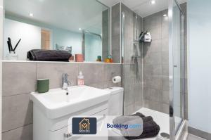 uma casa de banho com um lavatório branco e um chuveiro em Stylish Two Bed City Centre Apartment By Movida Property Group Short Lets & Serviced Accommodation Leeds em Leeds