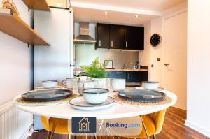 a kitchen with a table with dishes on it at Stylish Two Bed City Centre Apartment By Movida Property Group Short Lets & Serviced Accommodation Leeds in Leeds