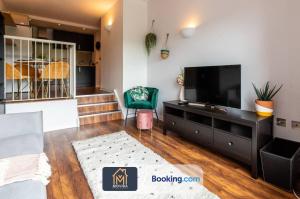 a living room with a television and a couch at Stylish Two Bed City Centre Apartment By Movida Property Group Short Lets & Serviced Accommodation Leeds in Leeds
