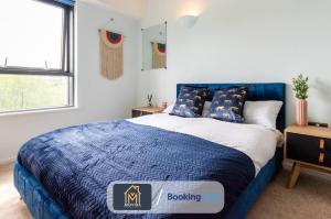 um quarto com uma cama azul e um cobertor azul em Stylish Two Bed City Centre Apartment By Movida Property Group Short Lets & Serviced Accommodation Leeds em Leeds