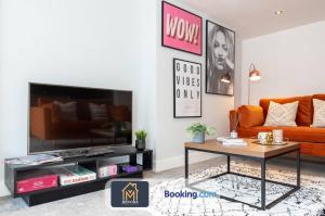 a living room with an orange couch and a coffee table at Stylish Two Bed Town Centre Apartment By Movida Property Group Short Lets & Serviced Accommodation With Parking in Harrogate