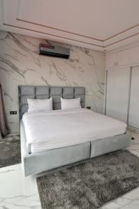 um quarto com uma cama branca e uma cabeceira de cama prateada em Villa moderne Marrakech em Marrakech