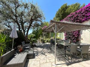 patio con tavolo, ombrellone e fiori di Villa Mougins Avec Piscine a Mougins