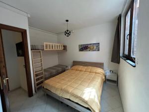 um pequeno quarto com uma cama e um sofá em La Villa dell Artista con vista mare e dune - IUN Q7440 em Torre dei Corsari