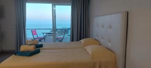 a bedroom with a large bed with a view of the ocean at Estrela do Mar in Albufeira