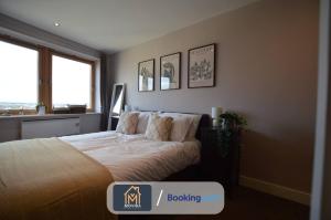 a bedroom with a bed and two windows at One Bed Docklands By Movida Property Group Short Lets & Serviced Accommodation Hunslet in Hunslet