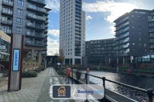a row of tall buildings next to a body of water at One Bed Docklands By Movida Property Group Short Lets & Serviced Accommodation Hunslet in Hunslet