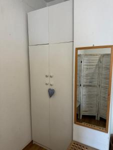 a white cabinet in a room with a mirror at Gemütliches komfortables Zimmer für 1 Person im Zentrum in Munich