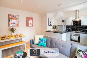 a living room with a couch and a kitchen at The Hyde Away Chic Urban Two Bedroom House By Movida Property Group Short Lets & Serviced Accommodation in Headingley