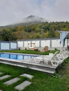 a group of white chairs sitting next to a pool at Qafqaz Mountside Chalet in Gabala