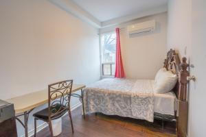 a bedroom with a bed and a desk and a table at Pembroke suites in Toronto