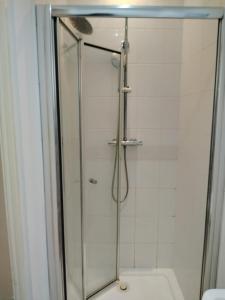 a shower with a glass door in a bathroom at Thales Home GFDBL1 in Barking