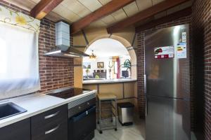 una cocina con nevera de acero inoxidable y un arco en Castell Bohio, en Urbanización Ses Palmeres