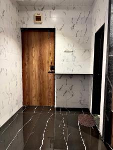 Cette chambre est dotée d'une porte en bois et de murs blancs. dans l'établissement Imagine Love, à Lonavala