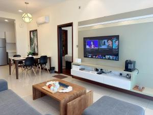 een woonkamer met een flatscreen-tv aan de muur bij Paragon Suites Holiday Short gateway Jacuzzi CIQ in Johor Bahru