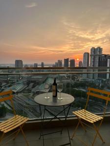 - une table avec deux verres de vin sur le balcon dans l'établissement Paragon Suites Holiday Short gateway Jacuzzi CIQ, à Johor Bahru