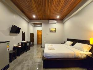 a bedroom with a large bed and a dining room at Baan Koh Kwang Pool Villa Krabi in Krabi town