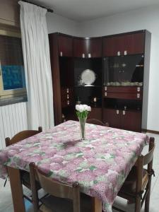 uma mesa de jantar com um vaso de flores em Appartamento da Sara rb em Paruzzaro