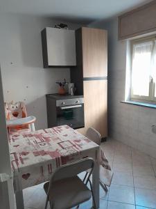 uma cozinha com uma mesa e cadeiras e uma mesa e uma mesa e uma cozinha em Appartamento da Sara rb em Paruzzaro