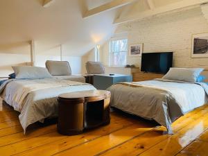 a room with two beds and a tv in it at Maison TURCOT in Saint-Hyacinthe