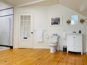 a white bathroom with a toilet and a sink at Maison TURCOT in Saint-Hyacinthe