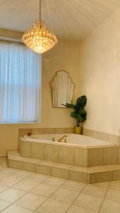 a large bathroom with a tub and a potted plant at Maison TURCOT in Saint-Hyacinthe