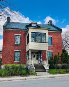 a red brick house with a white door at Maison TURCOT in Saint-Hyacinthe