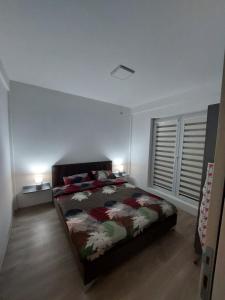 クマノヴォにあるLili`s Apartmentのベッドルーム1室(ベッド1台、ランプ2つ、窓付)