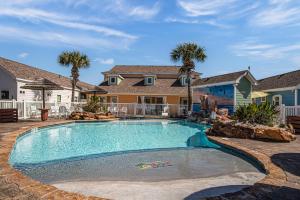 a swimming pool in front of a house at SeaKing Relaxation where the waves meet the shore and time slows down in Port Aransas