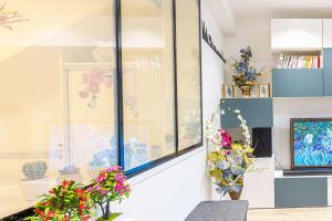 a room with a window with flowers on the wall at ParisMyHome - Air-conditioned, 2 shower rooms, 2 toilets in Paris