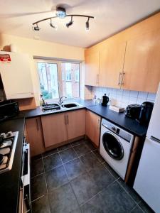 uma cozinha com um lavatório e uma máquina de lavar roupa em Apartment 9 3/4 em Watford