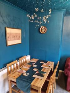 a dining room with a wooden table and blue walls at Apartment 9 3/4 in Watford