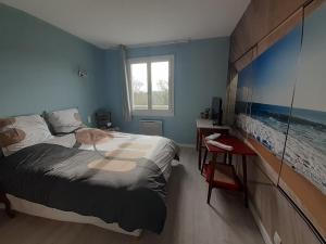 a bedroom with a bed and a desk and a window at Le Verger in Carnas