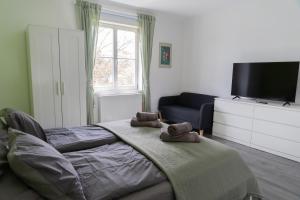Schlafzimmer mit einem Bett und einem Flachbild-TV in der Unterkunft WILSON's Home Baden City Center operated by revLIVING in Baden