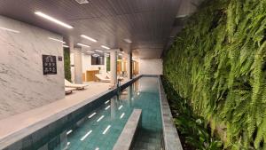 kryty basen z zieloną ścianą w obiekcie Studio Novo, aconchegante! w São Paulo
