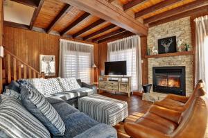a living room with a couch and a fireplace at Chalet 9006 Chemin des Alpages by Les Chalets Alpins in Stoneham