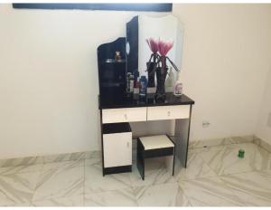 a desk with a vase with a flower on it at Belle Appartement avec Jaccuzzi à Diamniadio in Dakar