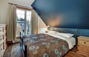 a bedroom with a bed and a blue wall at Chalet 9006 Chemin des Alpages by Les Chalets Alpins in Stoneham