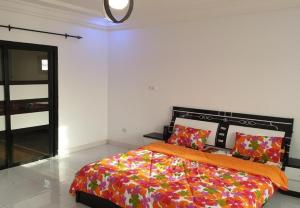 a bedroom with a bed with a colorful comforter at Belle Appartement avec Jaccuzzi à Diamniadio in Dakar